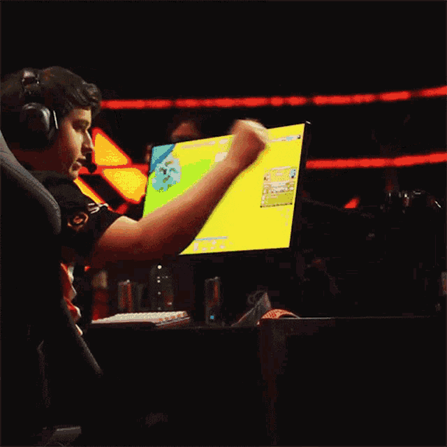 a man wearing headphones is playing a video game on a computer screen