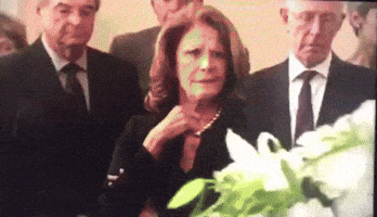 a woman in a black dress stands next to a man in a suit