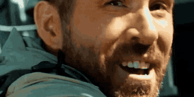 a man with a beard is smiling for the camera