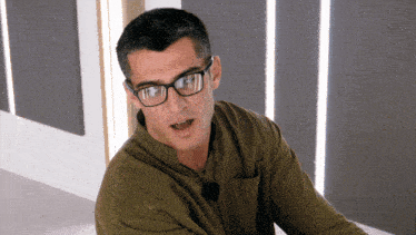 a man wearing glasses and a green shirt