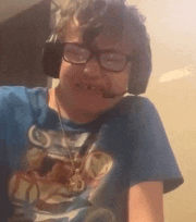 a young boy wearing headphones and a blue shirt is smiling and looking at the camera .