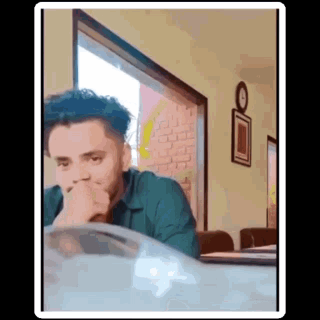 a man is sitting at a table in front of a window .