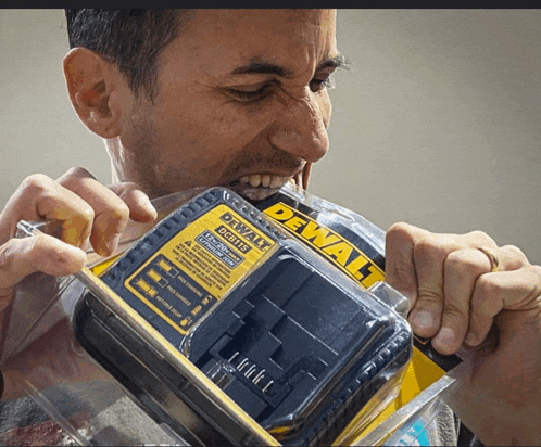 a man bites into a dewalt charger in a plastic package