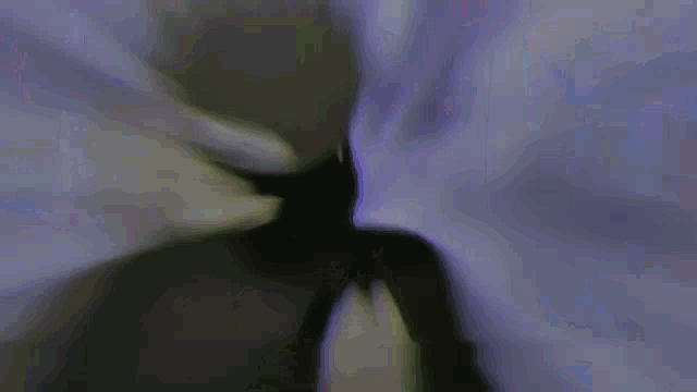 a man is wearing a virtual reality headset and dancing in front of a purple wall .