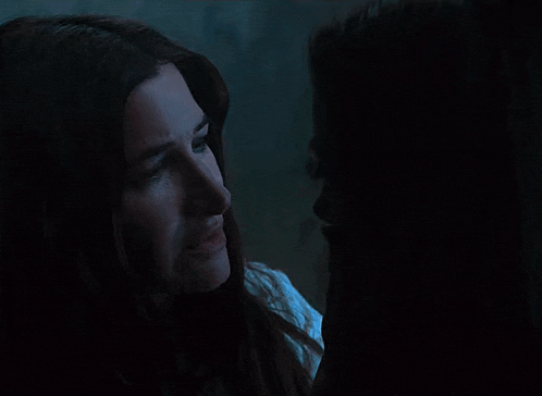 two women are looking at each other in the dark .