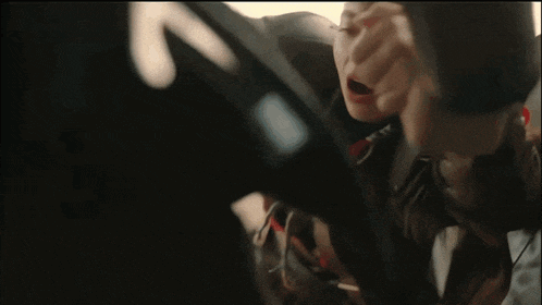 a person sitting in a car with the letter x on the side