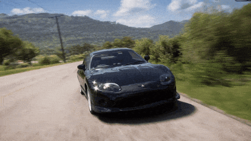 a black sports car is driving down a road