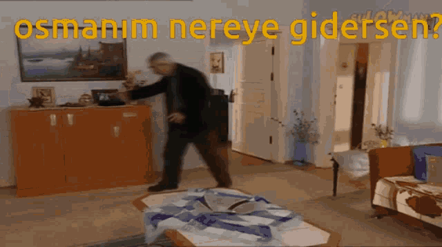 a man is standing in a living room with the words " osmanim nereye gidersen " written above him