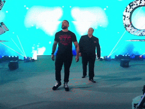 two men walking on a stage with one wearing a xtc shirt