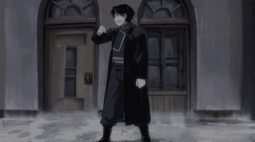 a man in a black coat is standing in front of a door in a dark room .