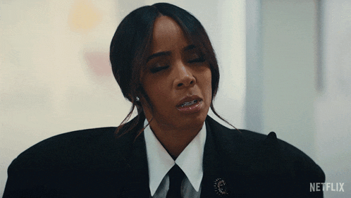 a woman wearing a suit and tie with a netflix logo on the bottom