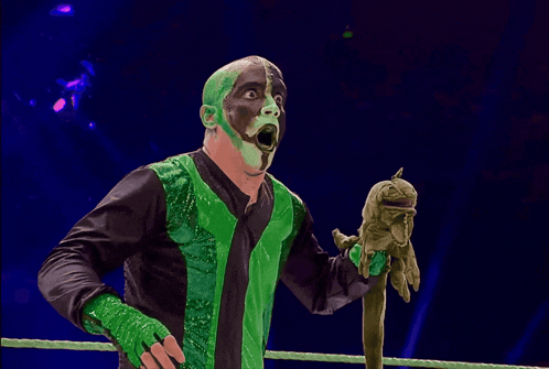 a man with green paint on his face is holding something