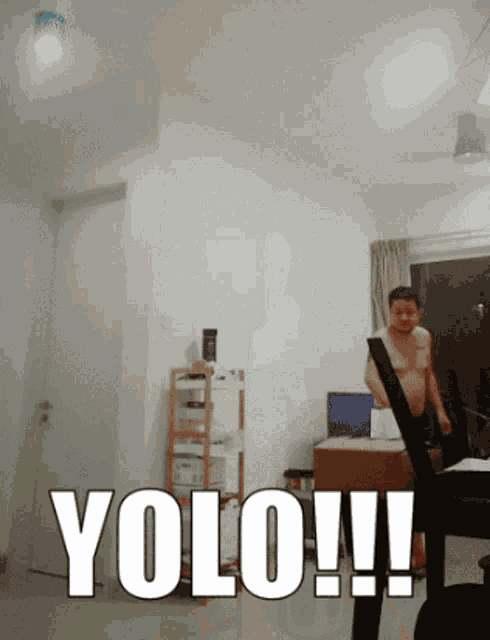 a man without a shirt is standing in a living room with the words yolo written in white