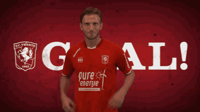 a man wearing a red shirt that says pure energie on it
