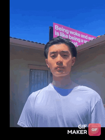 a man in a white shirt stands in front of a sign that says being woke and being a woman