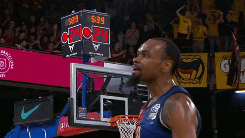 a basketball player stands in front of a scoreboard that says 9:39 on it