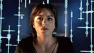 a woman stands in front of a screen with a pattern of crosses and numbers