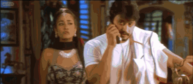 a man talking on a cell phone next to a woman