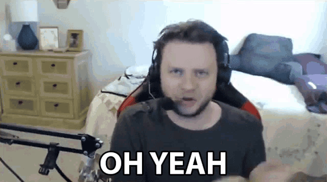 a man wearing headphones is saying oh yeah in a bedroom .