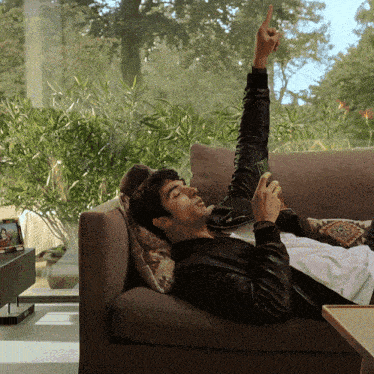 a man laying on a couch with his arm up