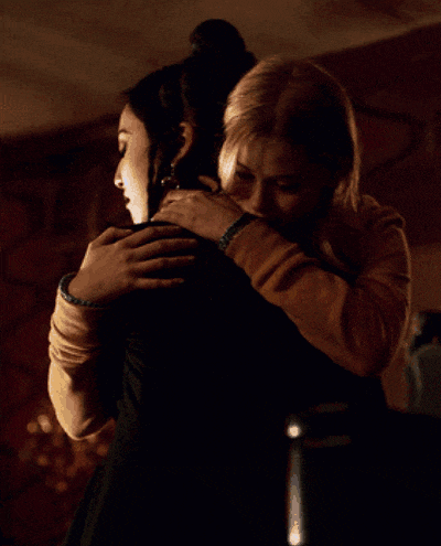 two women hugging in a dark room with one wearing a watch
