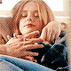a woman is laying on a couch with her hands on her chest .