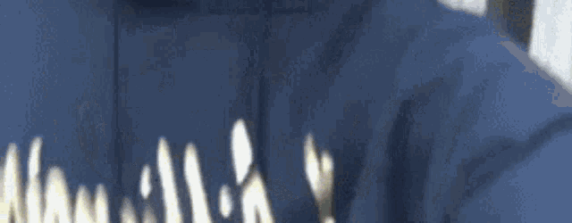 a close up of a person wearing a blue shirt that says ' hawaiian ' on it