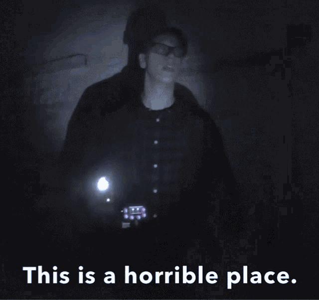 a person holding a flashlight in a dark room with the words this is a horrible place below them