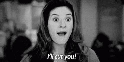 a woman is making a funny face and saying `` i 'll cut you '' in a black and white photo .