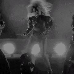 a black and white photo of three women dancing on a stage .