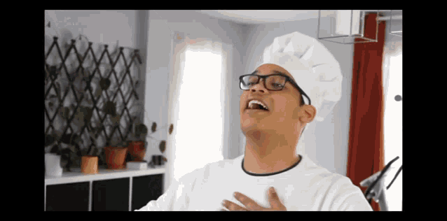 a man wearing glasses and a chef 's hat is singing