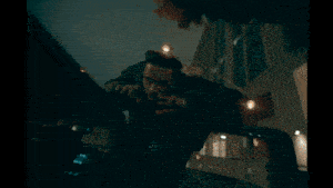 a car is driving down a street at night with a bright headlight
