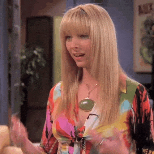 a woman wearing a colorful shirt and a green pendant necklace