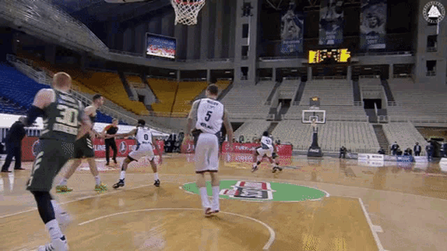 a basketball game is being played in an empty stadium with a player wearing number 5