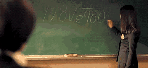 a girl is standing in front of a blackboard writing a math problem on it .