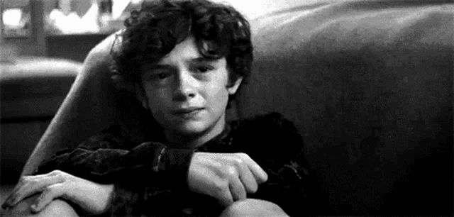 a young boy is crying while sitting on a couch .