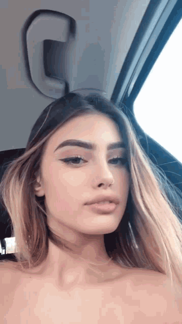 a woman is sitting in the back seat of a car and looking out the window .