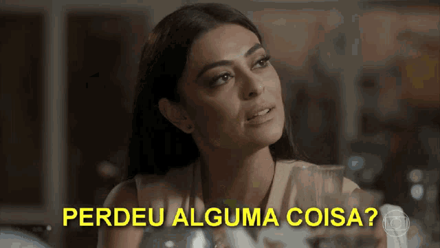 a woman sitting at a table with the words perdeu alguma coisa