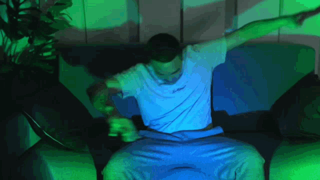a man sitting on a couch with his arms outstretched wearing a white shirt that says ' jetstar '