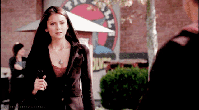a woman stands in front of a sign that says duff