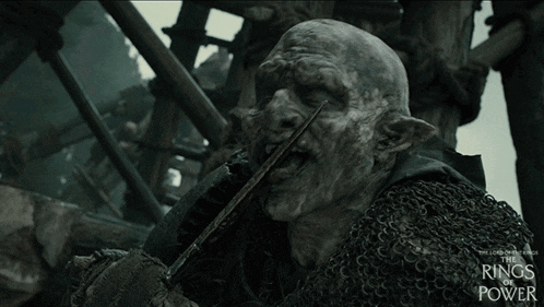 a poster for the lord of the rings power shows an orc holding a sword in his mouth