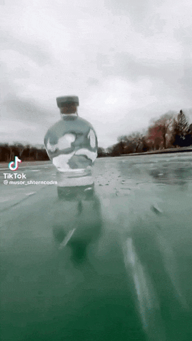 a bottle of water is floating in the water with a tiktok watermark at the bottom