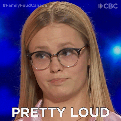 a woman wearing glasses says " pretty loud " in front of her