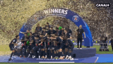 a group of soccer players standing under a banner that says " winners "