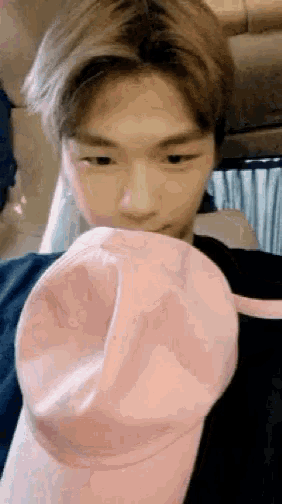 a close up of a person holding a pink baseball cap