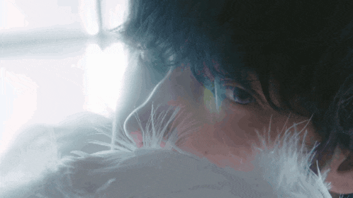 a close up of a person 's face with feathers covering their face