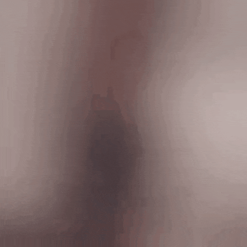 a woman in a black dress is standing in front of a couch