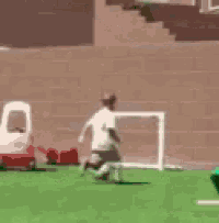 a person is playing soccer on a field with a goal .