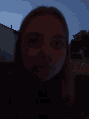 a blurry photo of a woman 's face with a blue sky in the background
