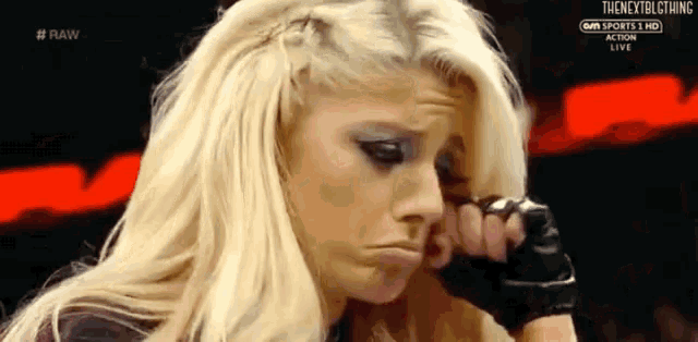a female wrestler is making a funny face while holding her hand to her face